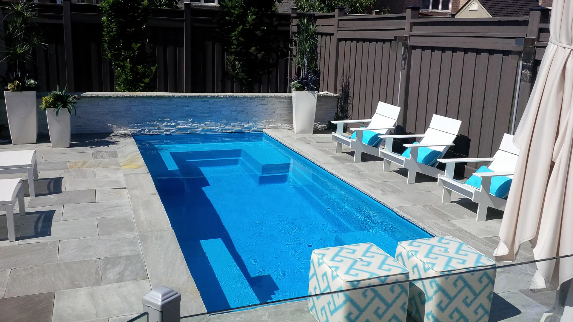 Leisure Pools Limitless rectangular fiberglass swimming pool with built-in spa and splash deck